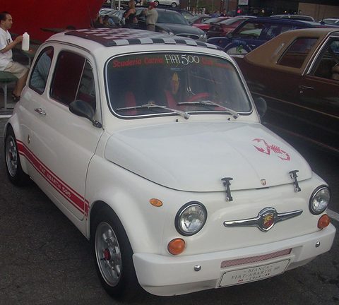 White Fiat 500 with red side stripes, a chequered roof, a scorpion on the bonnet and an Abarth moustache badge. Opens a larger view