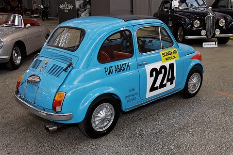 Light blue Fiat 500 seen from the rear left with Fiat Abarth on the door, a racing number and a twin exhaust. Opens a larger view