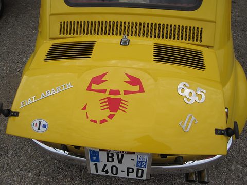 Yellow engine lid with cooling slots, a large red scorpion decal, chrome Fiat Abarth script and 695 SS numerals. Opens a larger view