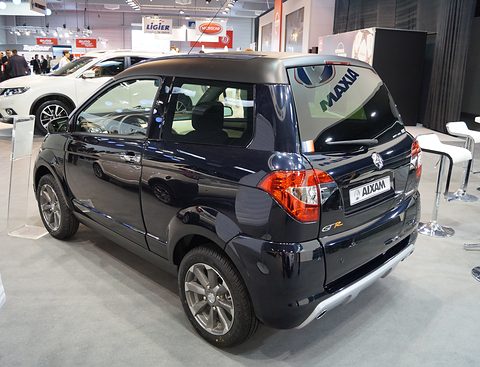 Rear of a black small crossover with a silver skid plate, an AIXAM plate and large lettering across its rear window. Opens a larger view