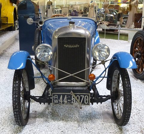 Front view of a small blue car with a chrome radiator, two headlamps, braced wings and a German number plate. Opens a larger view