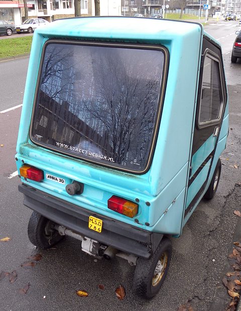 Rear of a turquoise box-shaped microcar with a large rear window, square tail lamps and a yellow Dutch number plate.