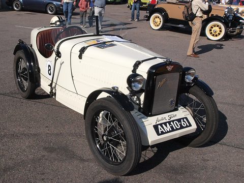 A white doorless two-seater with a black radiator, cycle wings and a Dutch number plate. Opens a larger view