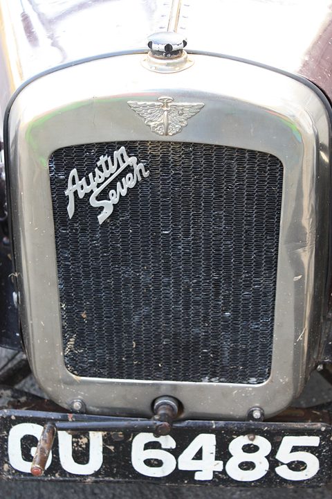 A nickel radiator shell with a winged cap and the words Austin Seven in script across the honeycomb. Opens a larger view