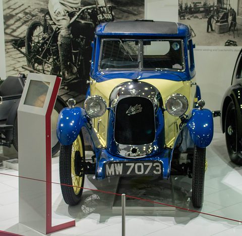 Head-on view of a yellow saloon with blue wings and roof and a polished radiator cowl. Opens a larger view