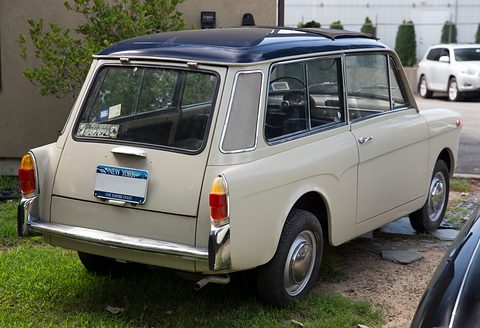 Beige small estate with a dark blue roof seen from the rear left, a New York plate on its tail door. Opens a larger view
