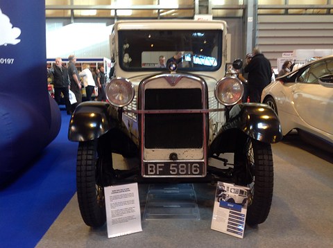 Front view of a cream saloon with black wings, a chrome radiator and plate BF 5816, information boards before it. Opens a larger view