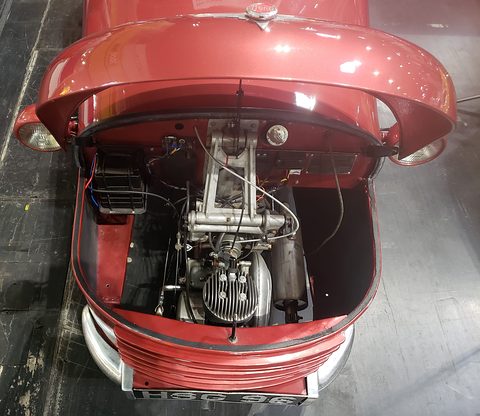Top-down view into a red nose compartment holding a finned engine and its mounting.