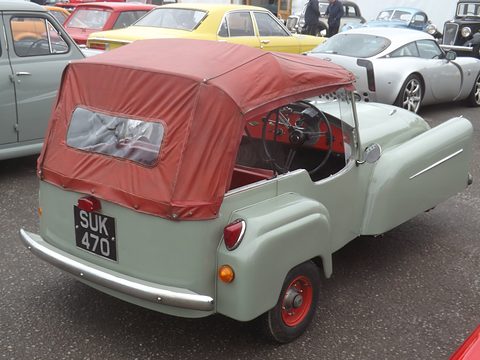 Pale green three-wheeler seen from behind with a maroon hood and rear window. Opens a larger view