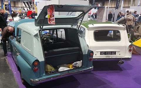 Two small three-wheel estates seen from behind, one with its tailgate raised, on a purple carpet.