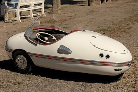 White pointed egg-shaped body with red pinstripes along the waist, a white bench behind. Opens a larger view