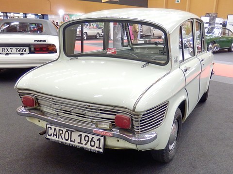 Rear view of a white four-door saloon with a louvred tail and a CAROL 1961 display plate. Opens a larger view
