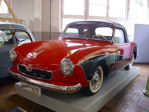 Red and black convertible coupé on a white plinth with a MAICO 500 Sport plate. Opens a larger view