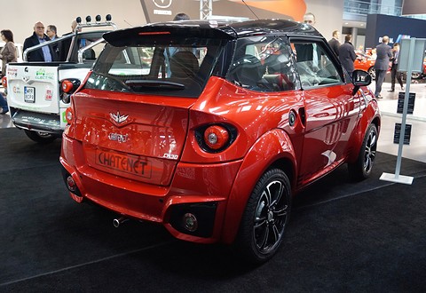 Rear of an orange small car with a black roof and spoiler, CHATENET moulded across the bumper, on a show stand. Opens a larger view