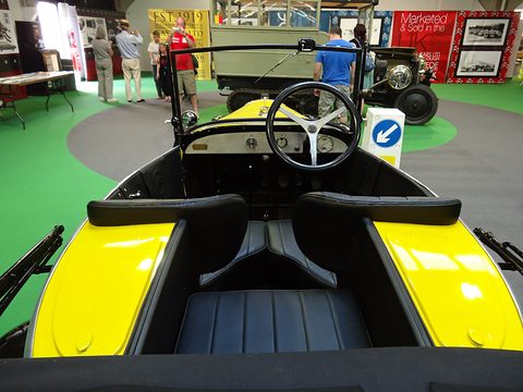 View from behind over a single rear seat set between two front seats toward the steering wheel.