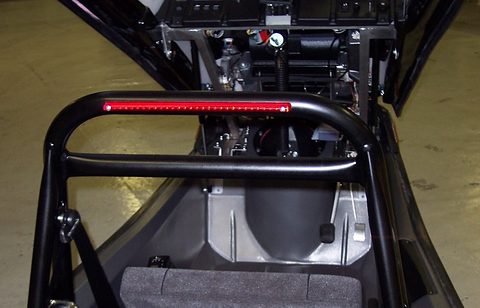 Black tubular roll bar with a red LED strip lamp, above a seat cushion and the bare chassis floor. Opens a larger view