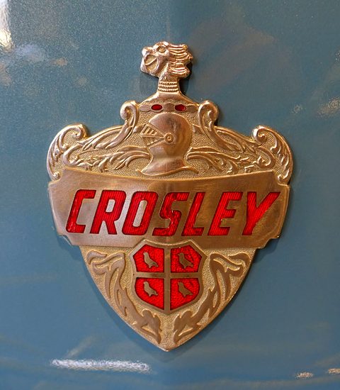 Gold and red enamel shield badge reading CROSLEY on light blue paint. Opens a larger view