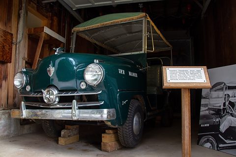 Dark green small open runabout with a fringed canopy and IKE and MAMIE on its door, a placard beside it. Opens a larger view