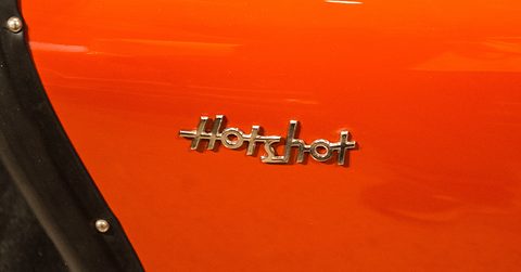 Chrome Hotshot script on glossy orange bodywork near the cockpit edge. Opens a larger view