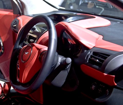 Red leather dashboard and door trim around a black steering wheel with a winged badge. Opens a larger view