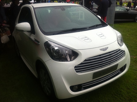 White city car head-on on grass, its slatted grille and bonnet vents to the fore. Opens a larger view