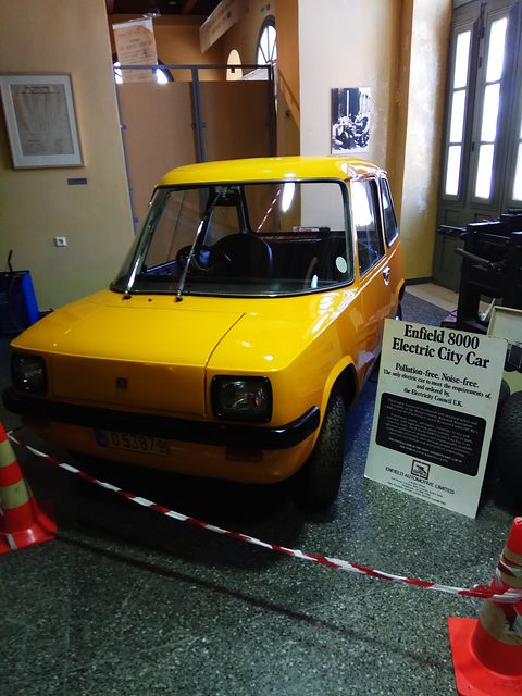 Electric car with an information board beside it, cordoned by cones and tape. Opens a larger view