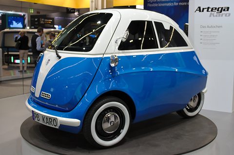 Blue and white bubble car with whitewall tyres and a PB KARO plate on a round dark turntable.