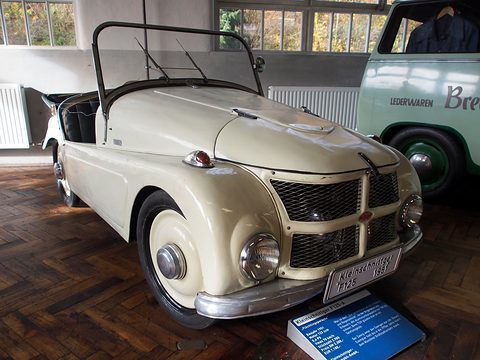 Cream open two-seater facing the camera with a Kleinschnittger F125 name plate, a pale green van behind. Opens a larger view