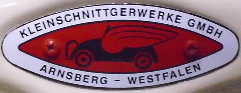 Oval enamel badge reading KLEINSCHNITTGERWERKE GMBH, ARNSBERG-WESTFALEN, around a red panel with a car drawing. Opens a larger view