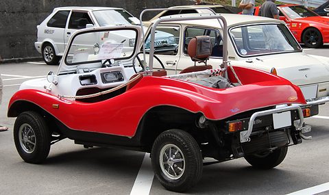 Rear three-quarter of a red doorless buggy with a white roll bar and dashboard, white saloons behind. Opens a larger view
