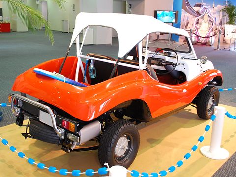 Rear three-quarter of an orange buggy with a white canvas top, inside a blue rope ring. Opens a larger view
