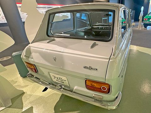 Rear three-quarter of a white boxy saloon with amber-and-red tail lamps and a plate reading Fellow. Opens a larger view