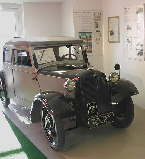Small two-tone saloon with a dummy radiator and a museum plate reading Framo Piccolo in front of it. Opens a larger view