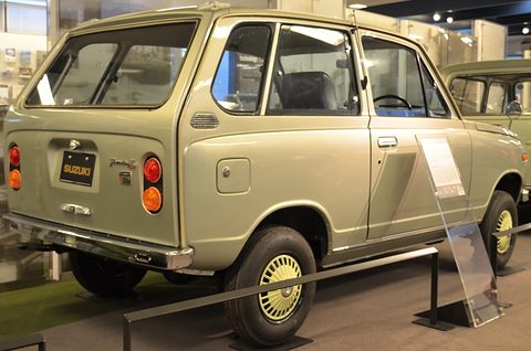 Rear three-quarter of a pale gold small estate van with a side-hinged tailgate. Opens a larger view