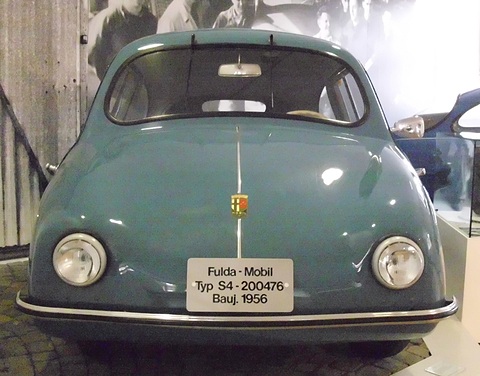 Blue-grey rounded car facing the camera on cobbles, a “Fulda-Mobil Typ S4 Bauj. 1956” plate on its nose. Opens a larger view