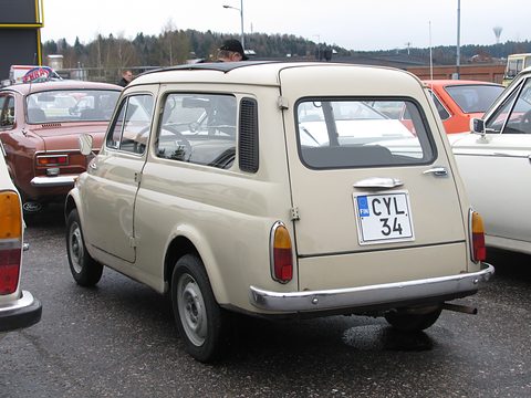 Rear of a beige small estate car parked on wet tarmac among other old cars. Opens a larger view