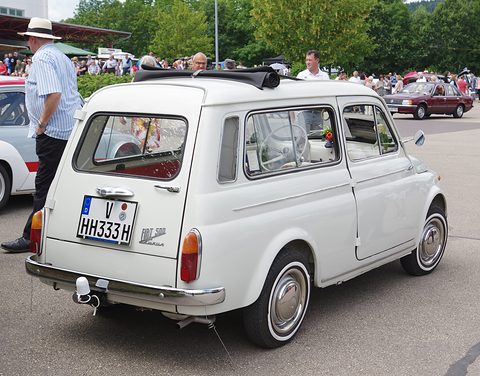 Rear of a white small estate car with a roof rack, chrome bumper and side-hinged rear door. Opens a larger view