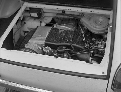 Looking down into an open floor hatch at a small horizontal twin-cylinder engine with its fan housing.