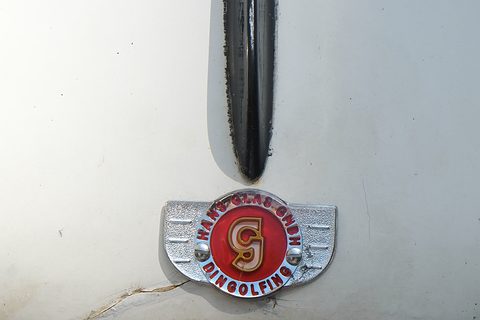 Round enamel badge with a red G and the words Hans Glas GmbH Dingolfing on white paint. Opens a larger view