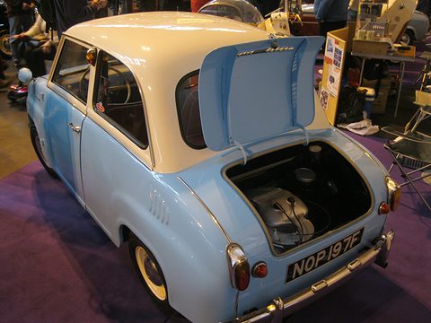 Pale blue saloon with a cream roof seen from behind, engine cover propped up showing the engine. Opens a larger view