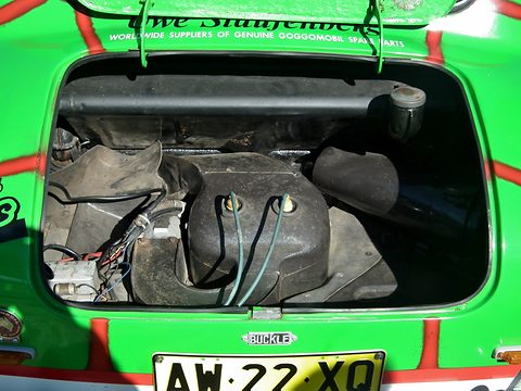 Open engine compartment of a bright green car with red stripes, Buckle dealer badge on the panel below. Opens a larger view
