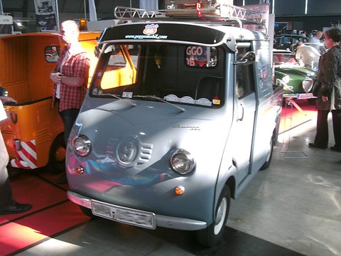 Grey pick-up with a canopy frame and a roof rack, seen from the front, show visitors around. Opens a larger view