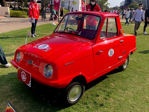 Red pickup seen almost from the front, a rally plate on the bonnet and round headlamps either side of a small grille. Opens a larger view