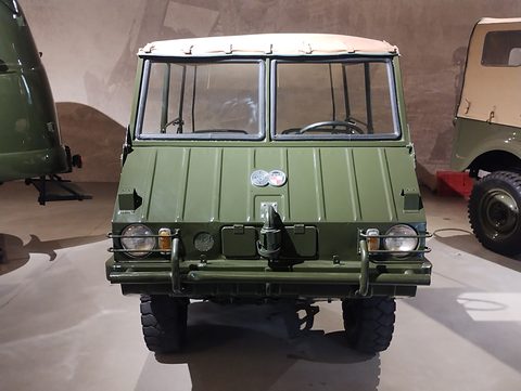 Front of an olive small 4x4 with a ribbed nose, glazed windscreen and a winch hook. Opens a larger view