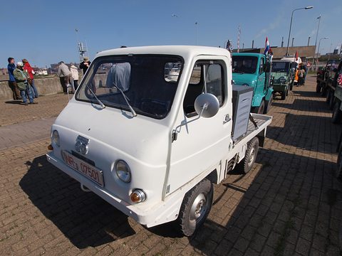 White small truck with a rounded plastic cab and a red Belgian plate, other Haflingers behind. Opens a larger view