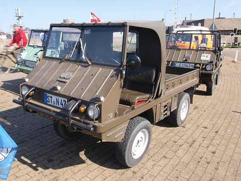 Olive small 4x4 with a cab top and a bull bar parked on brick paving, other Haflingers behind. Opens a larger view