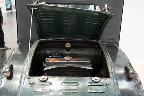 A louvred rear lid propped open over a small engine compartment with a single-cylinder engine and tank.
