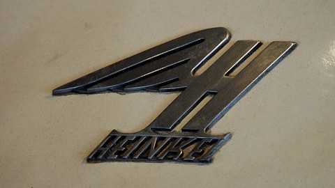 Close view of a winged H emblem above HEINKEL lettering on cream paint. Opens a larger view