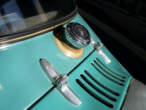 Chrome knurled filler cap above slotted louvres and a chrome handle on turquoise paint. Opens a larger view