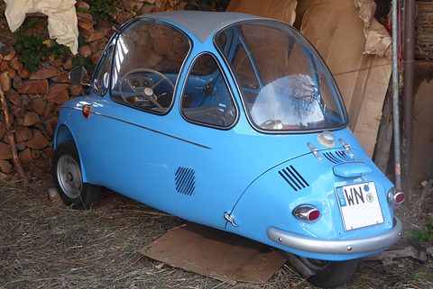 A pale blue Heinkel Kabine seen from behind in a barn. Opens a larger view